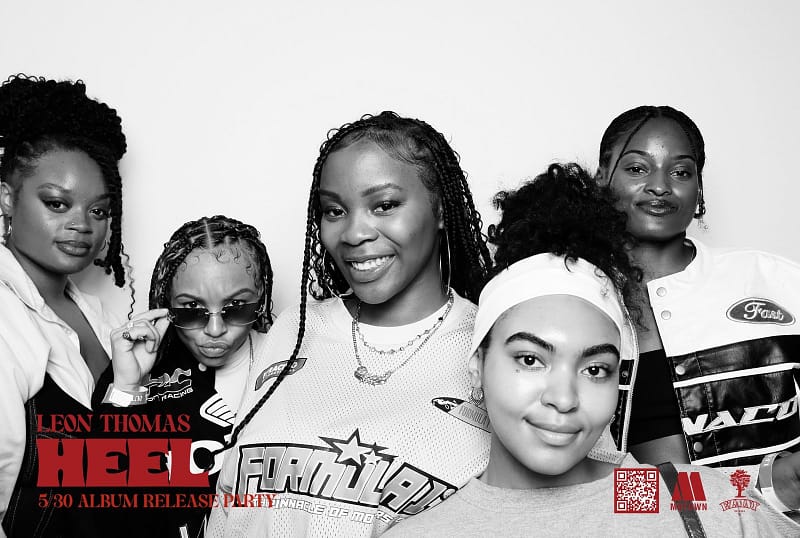 Guests pose for a photo at the Interscope Records album release party at Avalon Hollywood, surrounded by vibrant nightclub lighting.